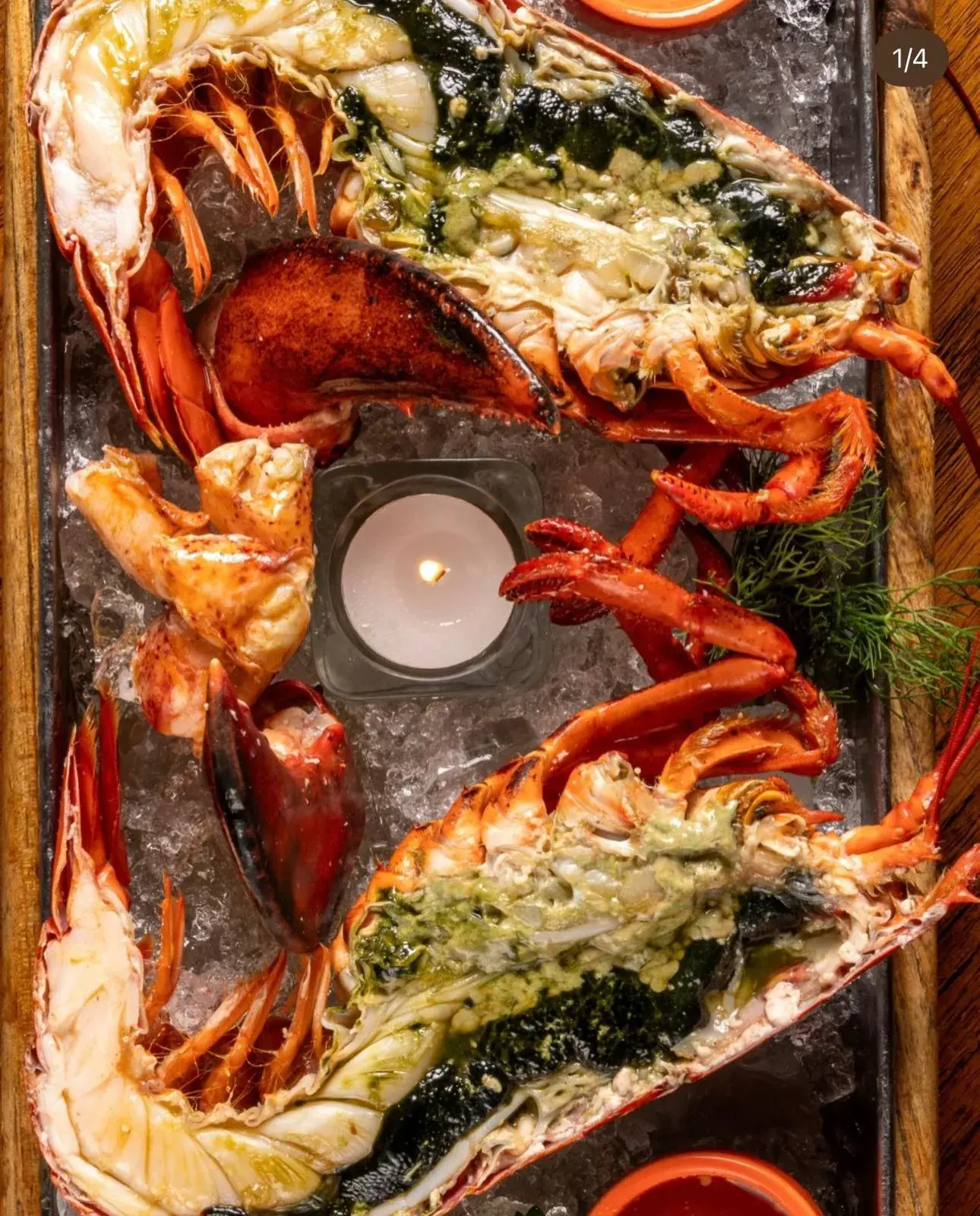 Aufgeschnittene Hummer-Hälften mit Kräuterbutter und Kerze